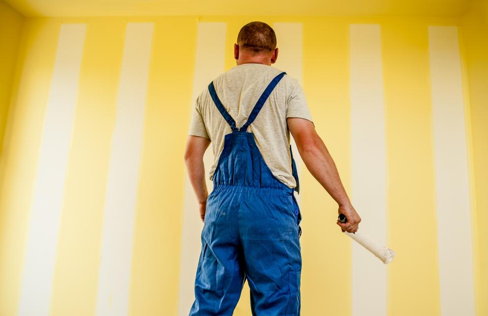 Painter applying a fresh coat to a feature wall